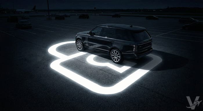 Veh&iacute;culo de alta gama estacionado de noche en el recinto de Valet Barajas con un gr&aacute;fico luminoso de seguridad rodeando el coche.