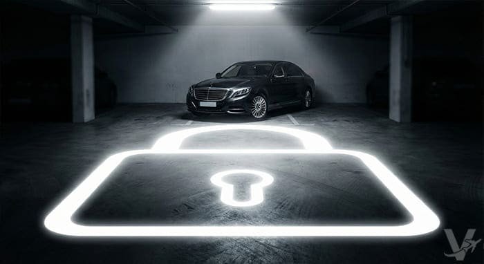 Veh&iacute;culo estacionado de noche bajo vigilancia con un gr&aacute;fico de candado luminoso que representa la protecci&oacute;n activa de Valet Barajas.