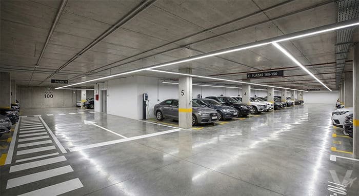 Interior de un parking subterr&aacute;neo moderno con iluminaci&oacute;n LED, videovigilancia y plazas numeradas de Valet Barajas.