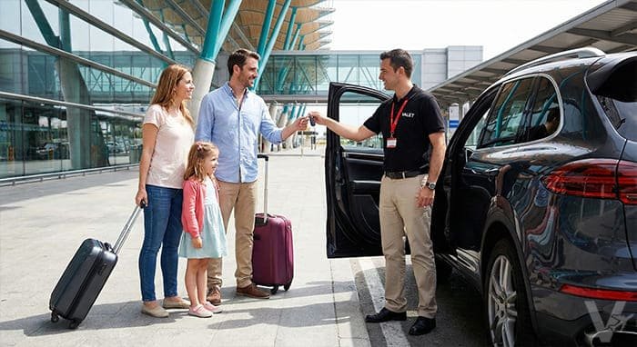 Conductor profesional de Valet Barajas recibiendo las llaves de un cliente en la zona de salidas de las terminales T1 y T2.