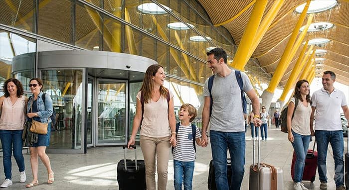 Familia caminando con maletas en T4 tras dejar su coche.